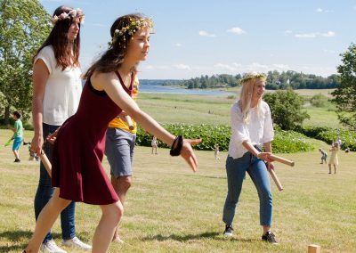 Students playing the traditional Swedish game "Kubb" on Midsummer's Eve